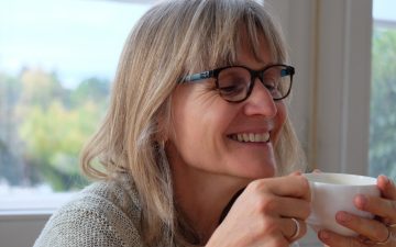 Irene Widmer-Huber in der Stube des Moosrain in Riehen trinkt aus einer weissen Tasse.