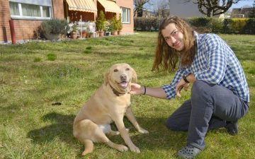 Ein Mann mit seinem Hund im Garten.