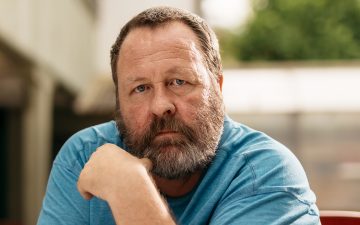 Ein bärtiger Mann blickt traurig in die Kamera.