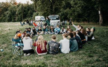 Jugendliche Lagergruppe versammelt im Kreis in der Natur.